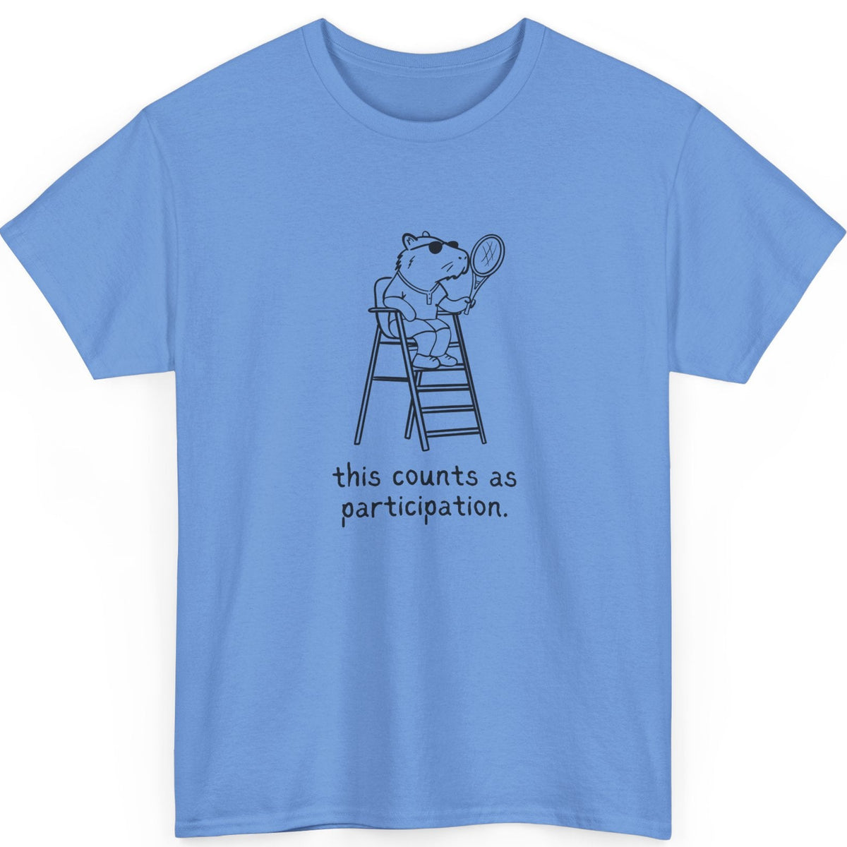 Blue t-shirt with a graphic of a capybara on a tennis judge stand and text 'this counts as participation.'
