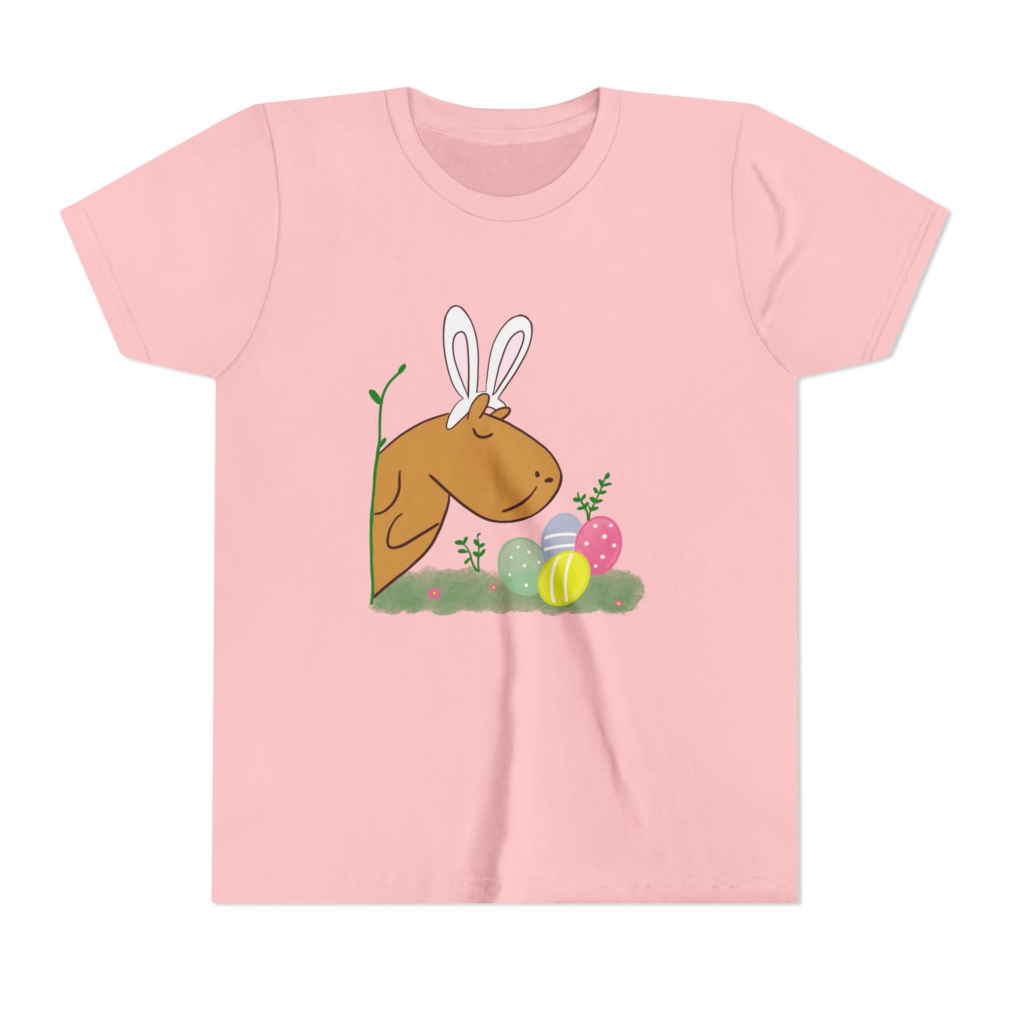 Cute pink kids' t-shirt with an illustration of a capybara wearing bunny ears and surrounded by Easter eggs and plants.