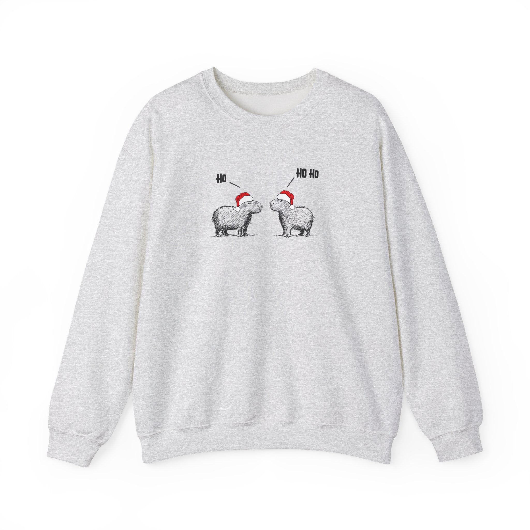 A light gray heather crewneck sweatshirt featuring a graphic of two capybara animals wearing red Santa hats facing each other, with 'HO HO HO' text above them, displayed on a clean white background.
