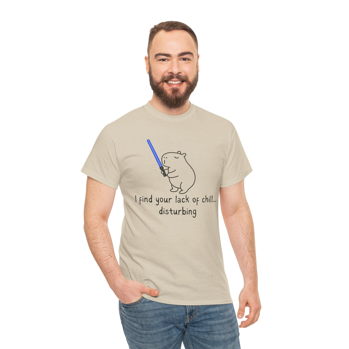 Capy Life beige cotton t-shirt featuring a hand-drawn capybara holding a blue lightsaber with funny Star Wars text.