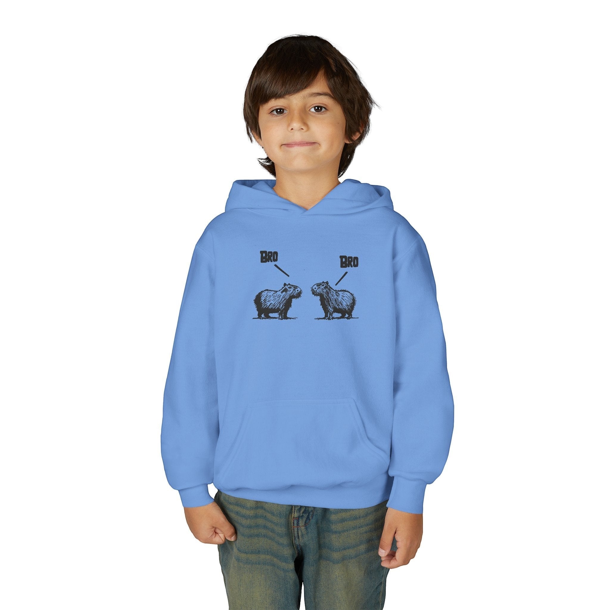 A young boy wearing a light blue Capy Life kids hoodie featuring a funny sketch of two capybaras saying Bro.