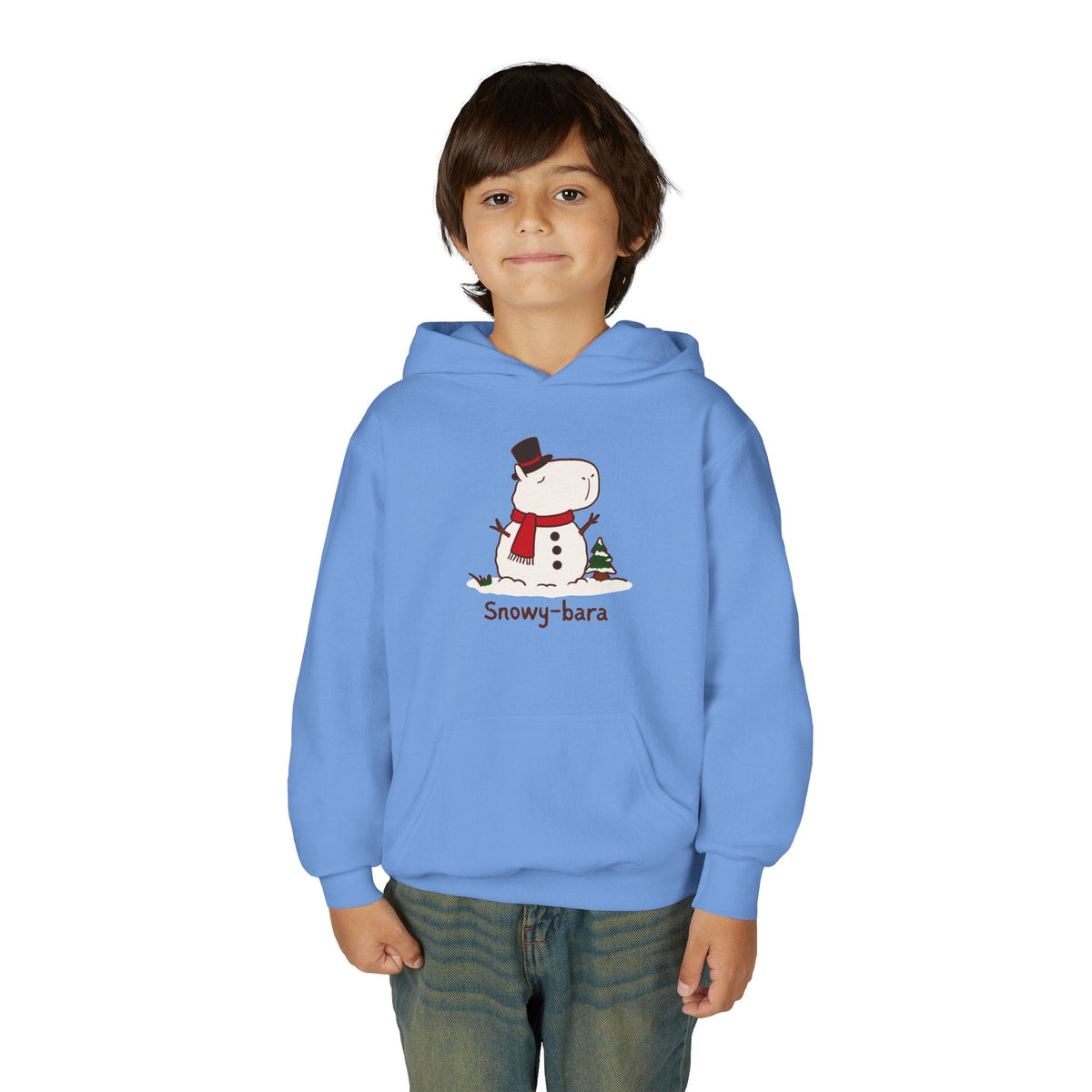 A young boy wearing a light blue Capy Life pullover hoodie featuring a cute Snowy-bara capybara snowman graphic.