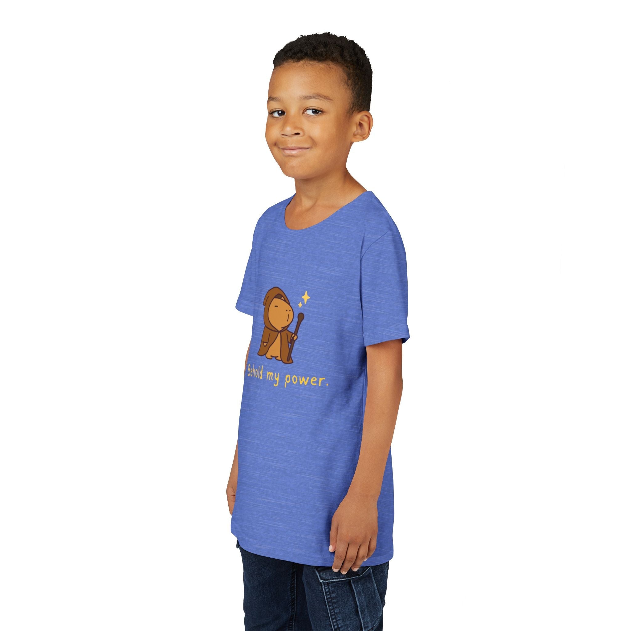 A young boy wearing a Capy Life blue cotton t-shirt featuring a cute wizard capybara graphic and Behold My Power text