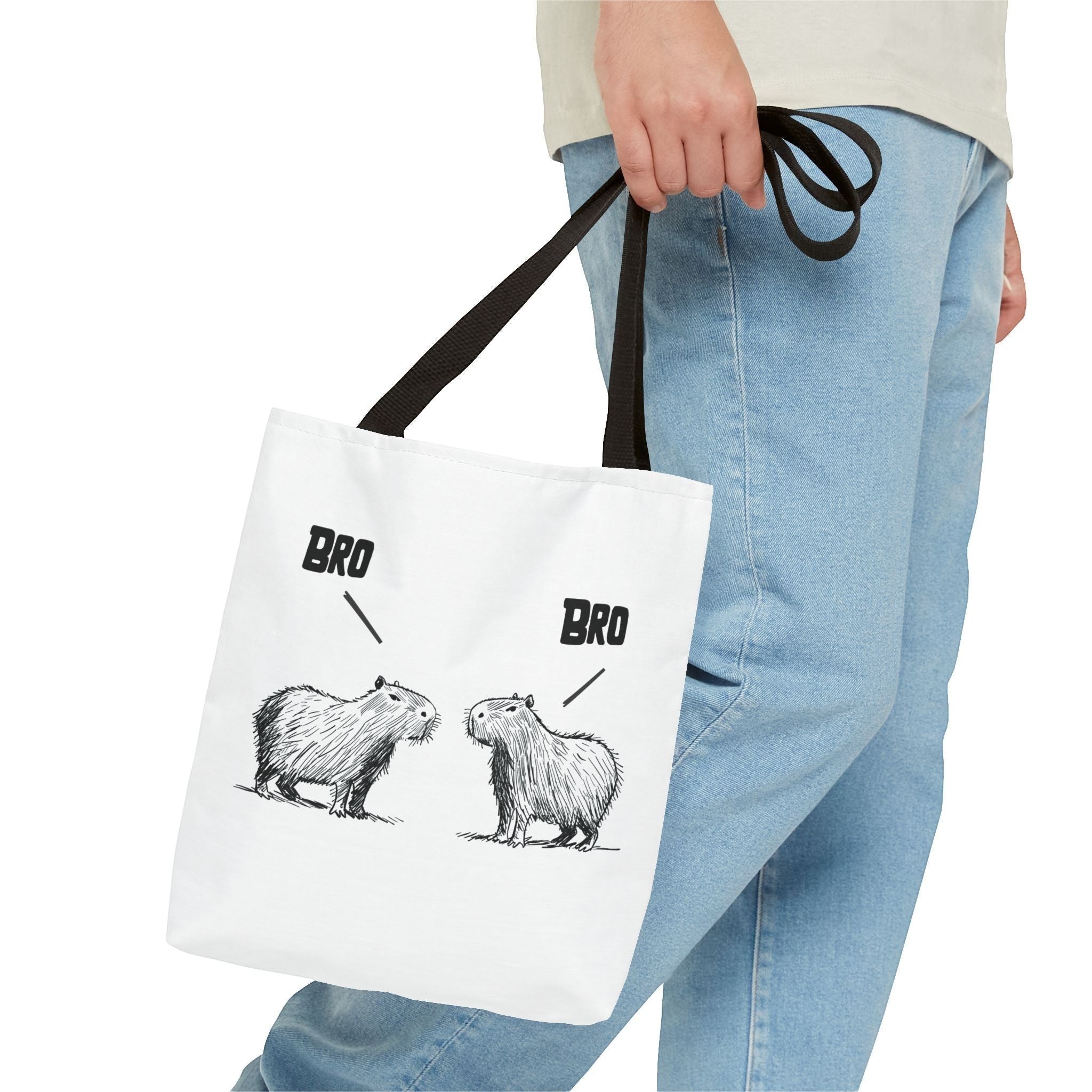 Capy Life white canvas tote bag featuring a funny sketch of two capybaras saying Bro to each other, held by a person.