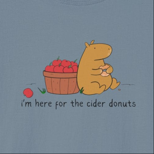 Capy Life softstyle t-shirt featuring a hand-drawn capybara eating a cider donut next to a basket of red apples.