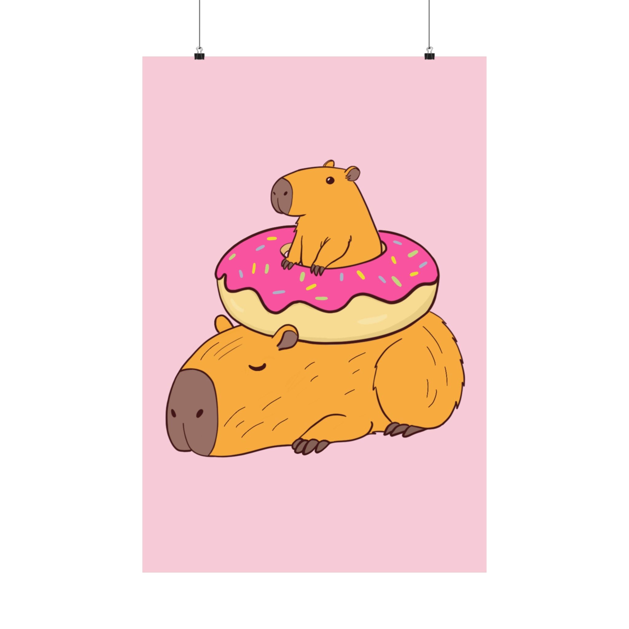 Capy Life wall art print featuring a cute capybara lounging under a pink frosted donut on a soft pink background.