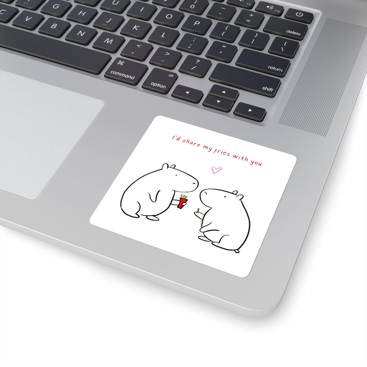 Capy Life square vinyl sticker featuring two cute capybaras sharing fries, applied to a silver laptop surface.