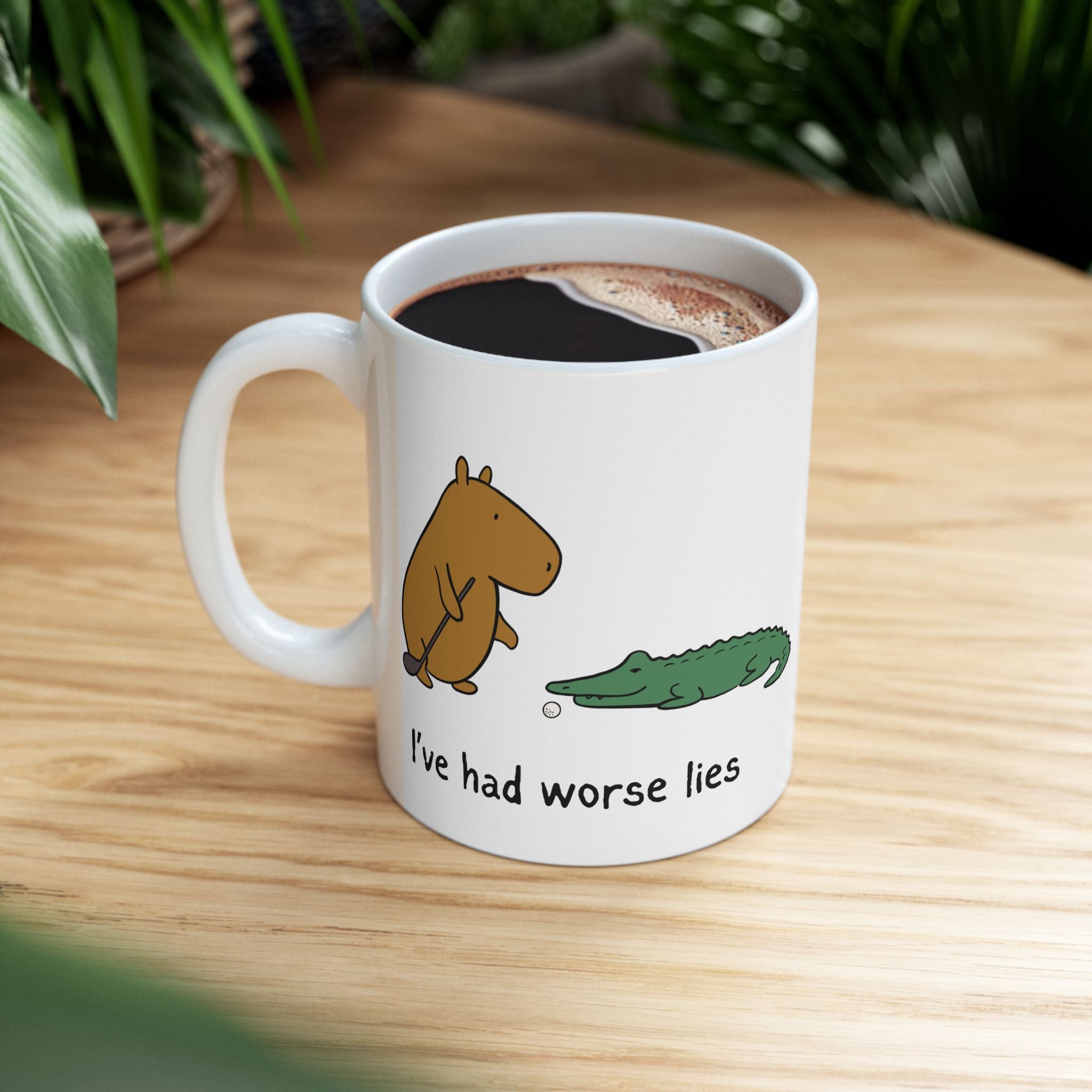 Capy Life ceramic coffee mug featuring a capybara and alligator with the text I have had worse lies on a wooden table