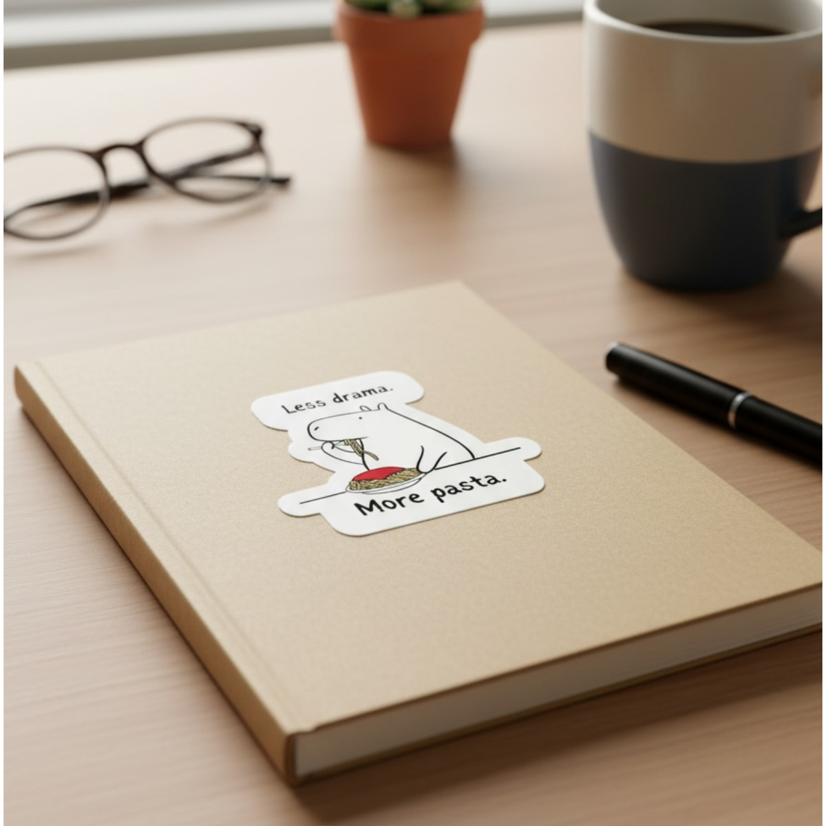 Capy Life die cut sticker of a capybara eating spaghetti on a tan notebook with the text Less drama More pasta