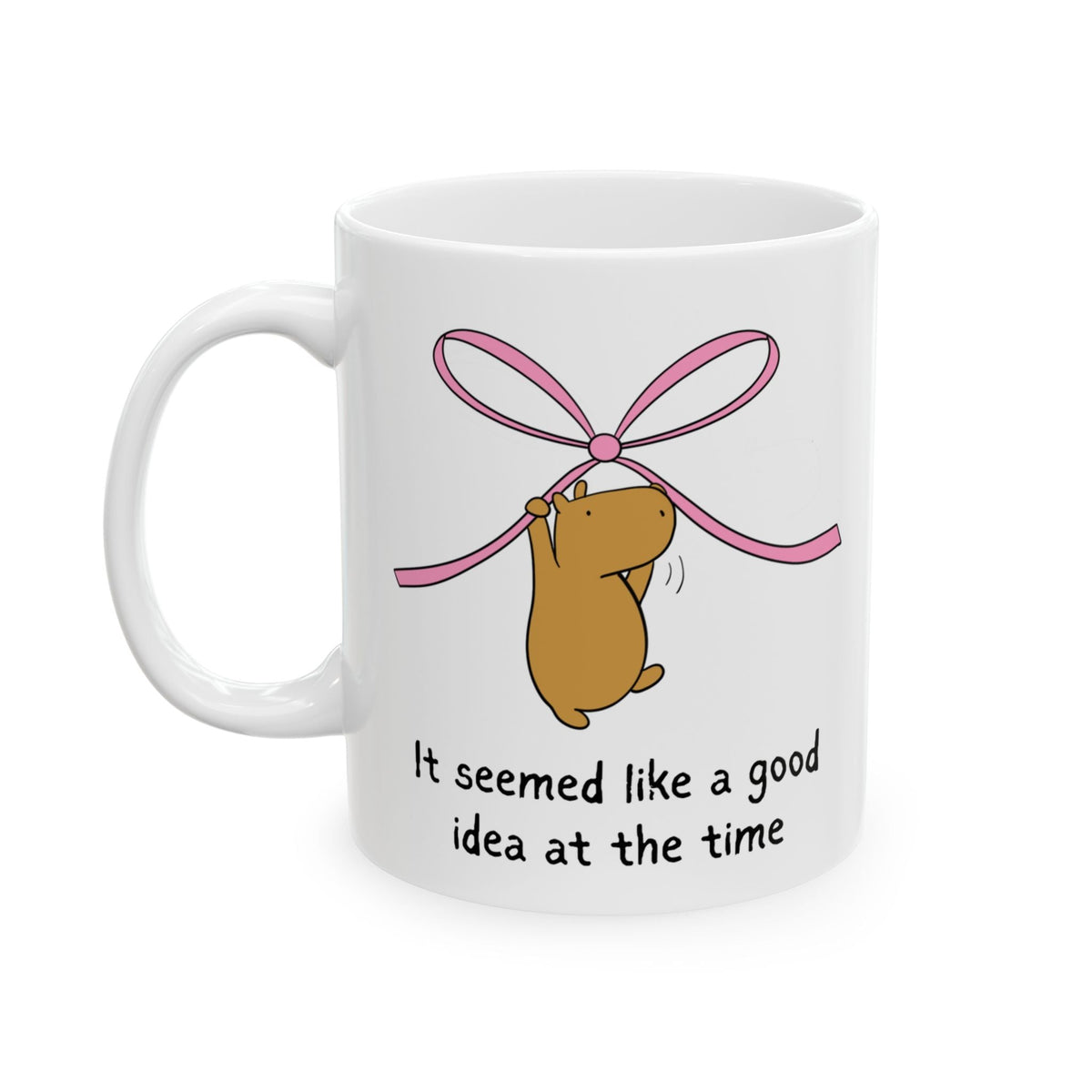Capy Life white ceramic coffee mug featuring a cute capybara hanging from a pink ribbon with funny text