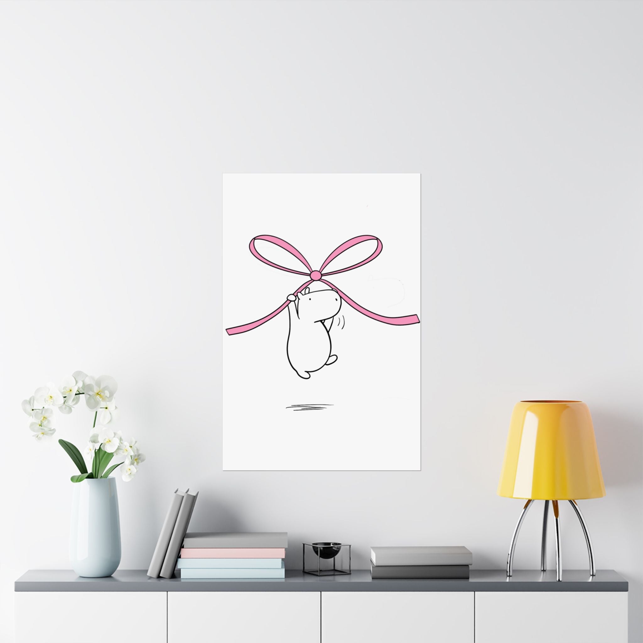 Capy Life nursery wall art featuring a minimalist capybara illustration floating while holding a soft pink bow.