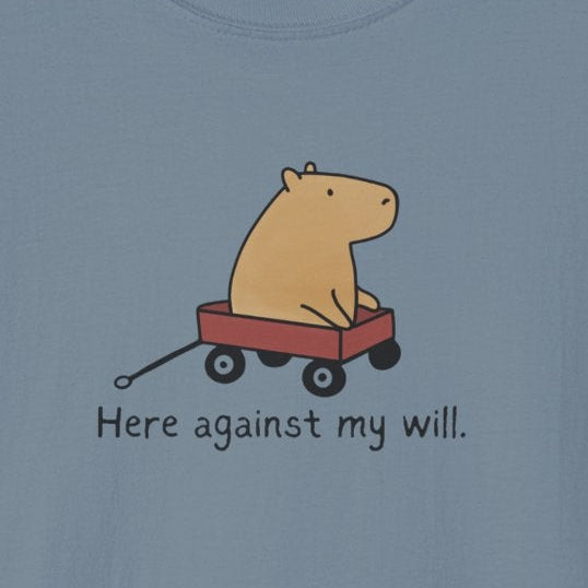 Capy Life minimalist blue t-shirt featuring a hand-drawn capybara in a red wagon with the text Here against my will