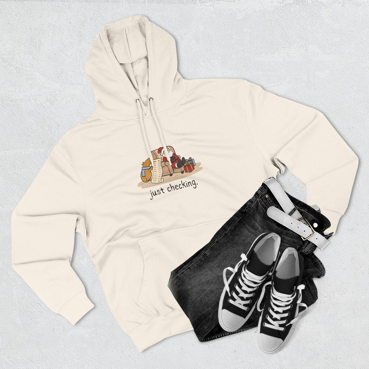 Capy Life cream fleece hoodie featuring a funny capybara illustration and the text just checking, styled with jeans.
