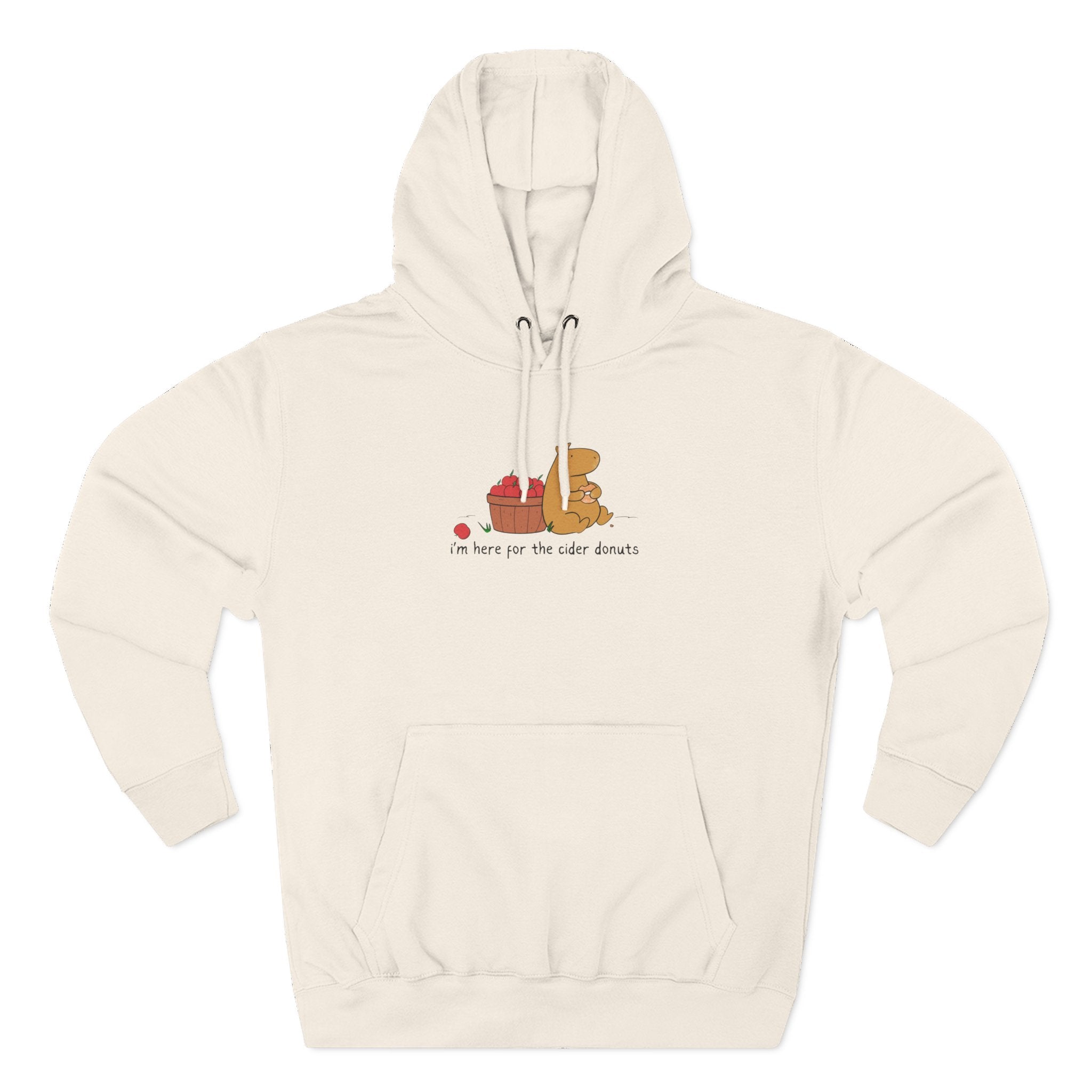 Capy Life cream fleece hoodie featuring a hand-drawn capybara eating a cider donut next to a basket of red apples.