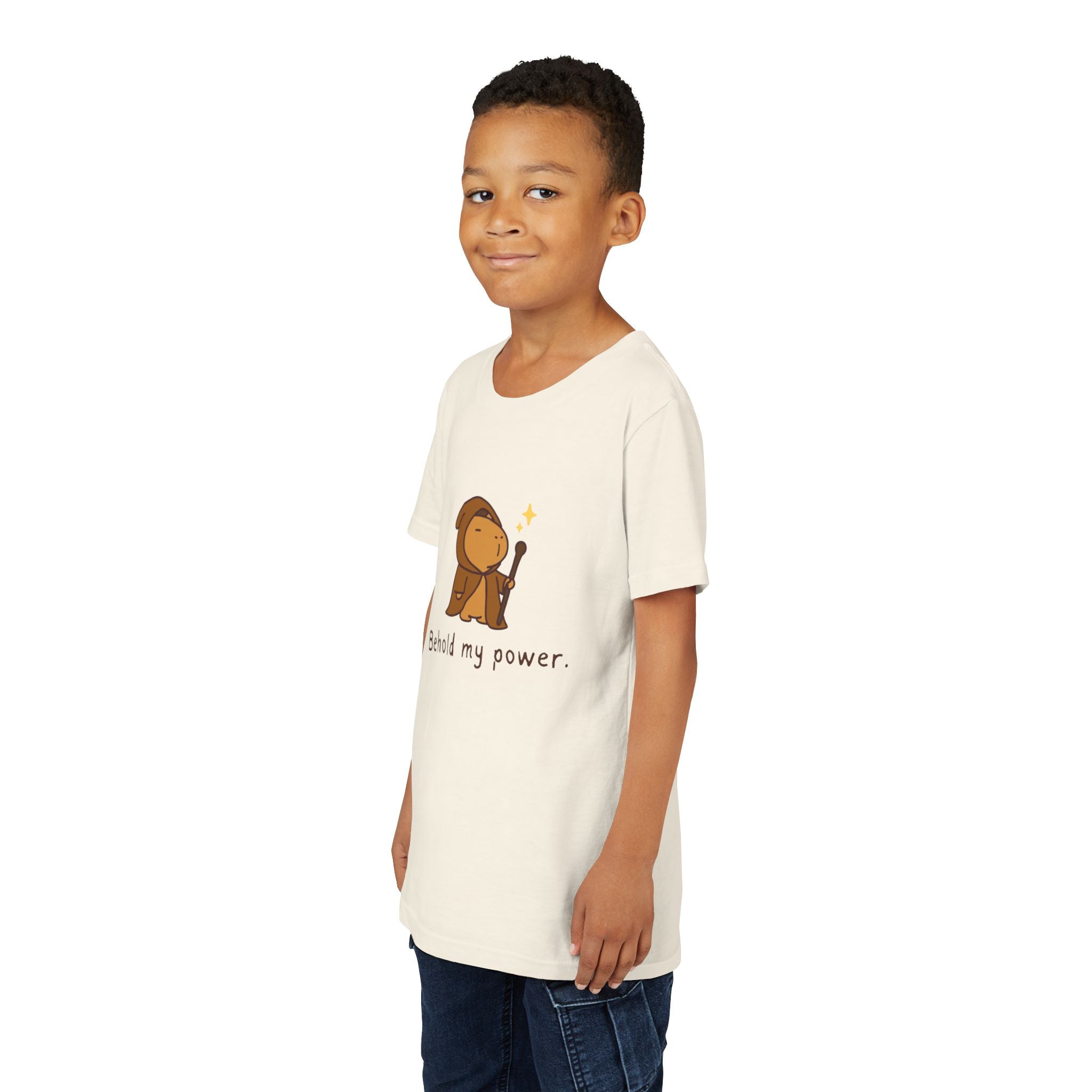 Capy Life kids t-shirt in cream featuring a cute wizard capybara graphic with the text Behold my power on a young boy