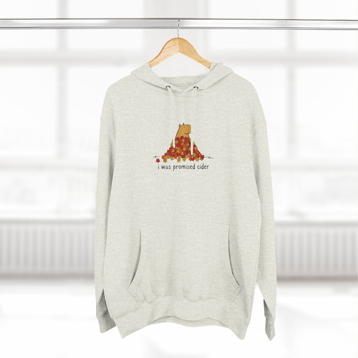 Capy Life light grey fleece hoodie featuring a graphic of a capybara in autumn leaves with the text I was promised cider