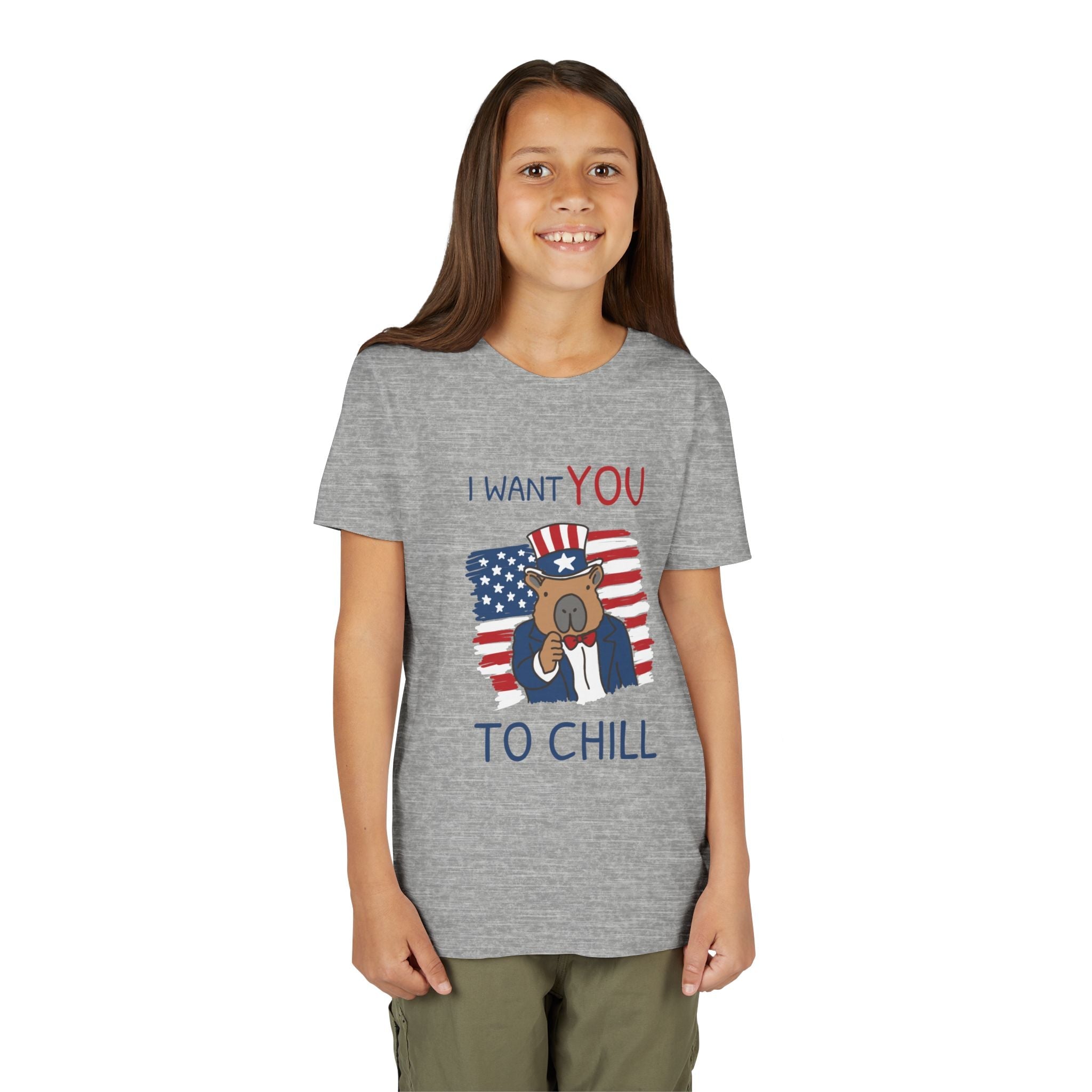 A young girl wearing a Capy Life grey t-shirt featuring a patriotic capybara graphic with the text I Want You To Chill