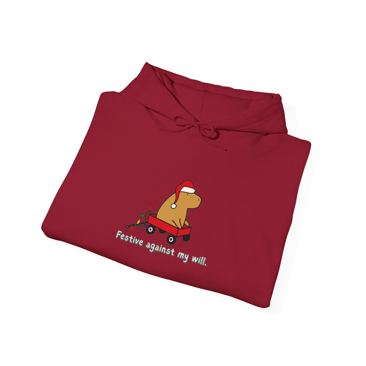 Capy Life red hoodie featuring a graphic of a capybara in a wagon with a Santa hat and text Festive against my will.