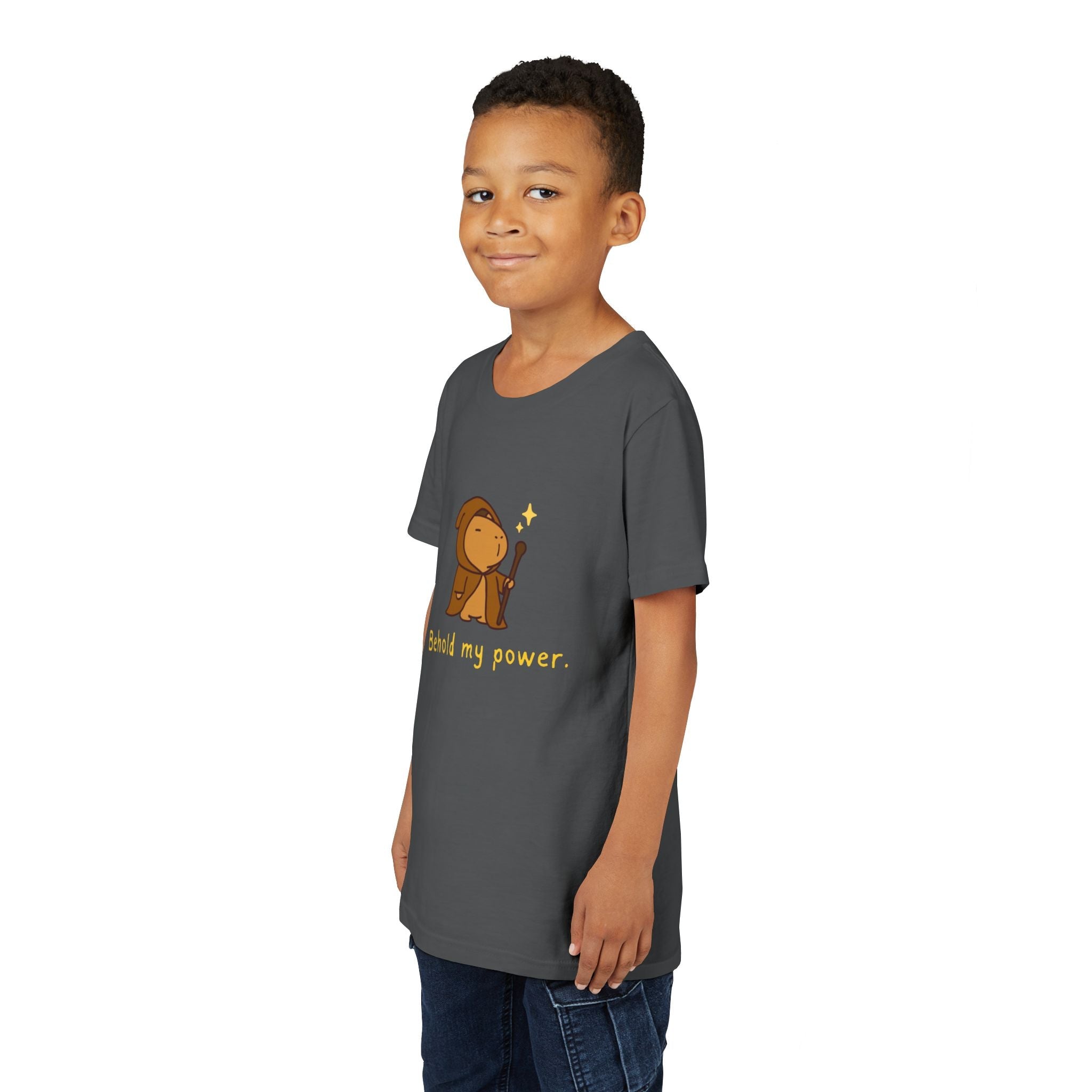 A young boy wearing a dark grey Capy Life cotton t-shirt featuring a cute wizard capybara graphic and text.