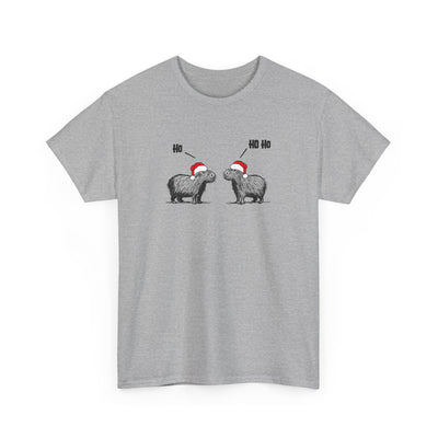 A heather gray short-sleeve crewneck t-shirt featuring a graphic of two capybara animals wearing red and white Santa hats, with 'Ho' text above them, displayed on a clean white background.