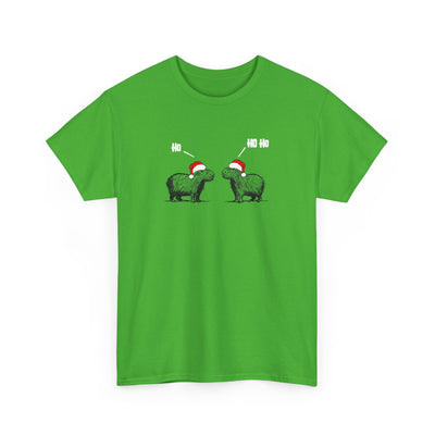 A bright green short-sleeve crewneck t-shirt featuring a graphic of two green capybara animals wearing red Santa hats, with white text above them, displayed on a clean white background.