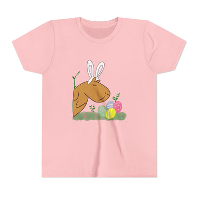 Cute pink kids' t-shirt with an illustration of a capybara wearing bunny ears and surrounded by Easter eggs and plants.