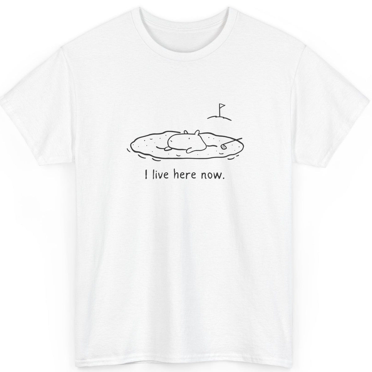 White t-shirt with black capybara in a sand bunker graphic and text 'I live here now.' on a white background