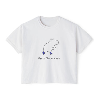White boxy t-shirt with illustration of a hippo on roller skates and text "Off to Shenan-again