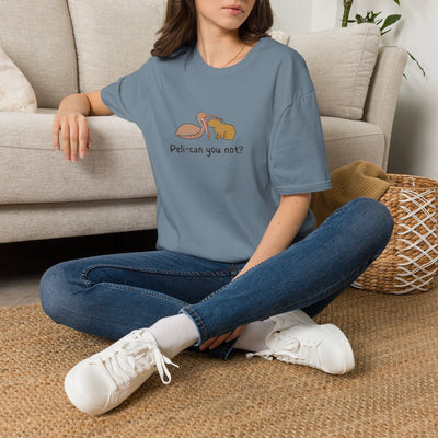 Person wearing a blue t-shirt with a capybara and pelican graphic design sitting on a carpeted floor.
