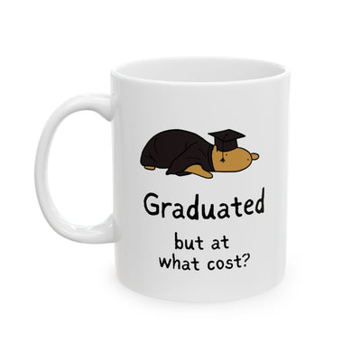 White mug with a cartoon capybara in a graduation cap and gown and text 'Graduated but at what cost?' on a white background