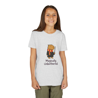A young girl wearing a Capy Life grey cotton t-shirt featuring a wizard capybara graphic and Magically Unbothered text.
