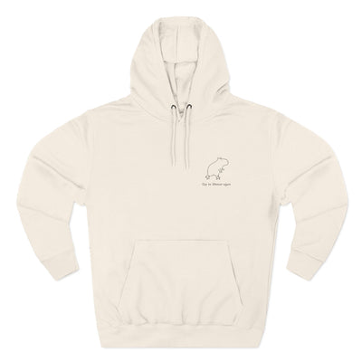 Cream-colored pullover hoodie with minimalist capybara embroidery and text "Off to Shenan-again