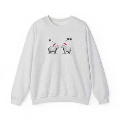 A light gray heather crewneck sweatshirt featuring a graphic of two capybara animals wearing red Santa hats facing each other, with 'HO HO HO' text above them, displayed on a clean white background.