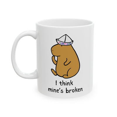 White mug with a cartoon capybara wearing a thinking cap and text 'I think mine's broken' on a white background
