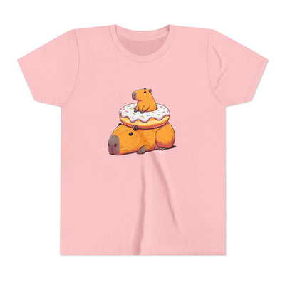 Unisex youth t-shirt featuring a cute, cartoon capybara resting on a donut with icing and sprinkles on a pink background.