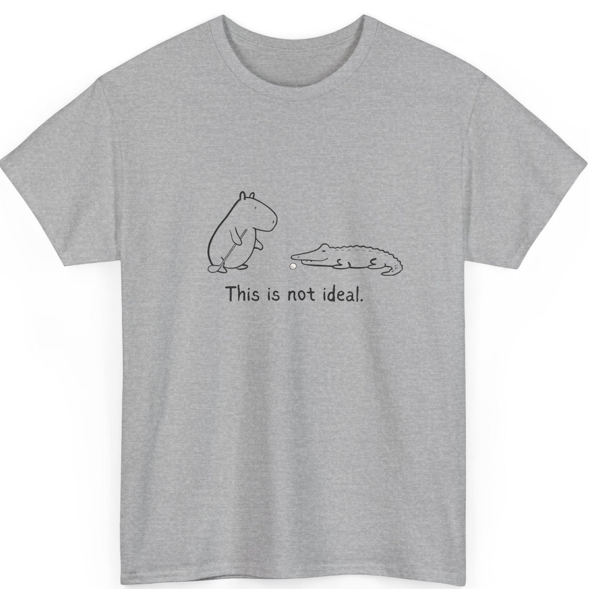 Gray t-shirt with capybara and alligator golf ball graphic and text 'This is not ideal' on a white background