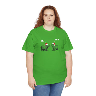 A woman with red hair wearing a bright green short-sleeve crewneck t-shirt featuring a graphic of two fluffy capybara wearing red Santa hats, with 'Ho Ho Ho' text above them,