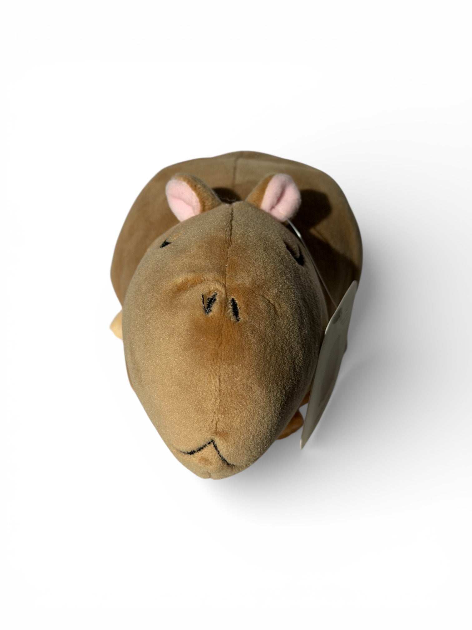 Top-down front view of Gene capybara plush showing embroidered face and pink ears