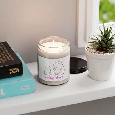 Capy Life Always There candle with capybara doodle on a windowsill next to a succulent and books.