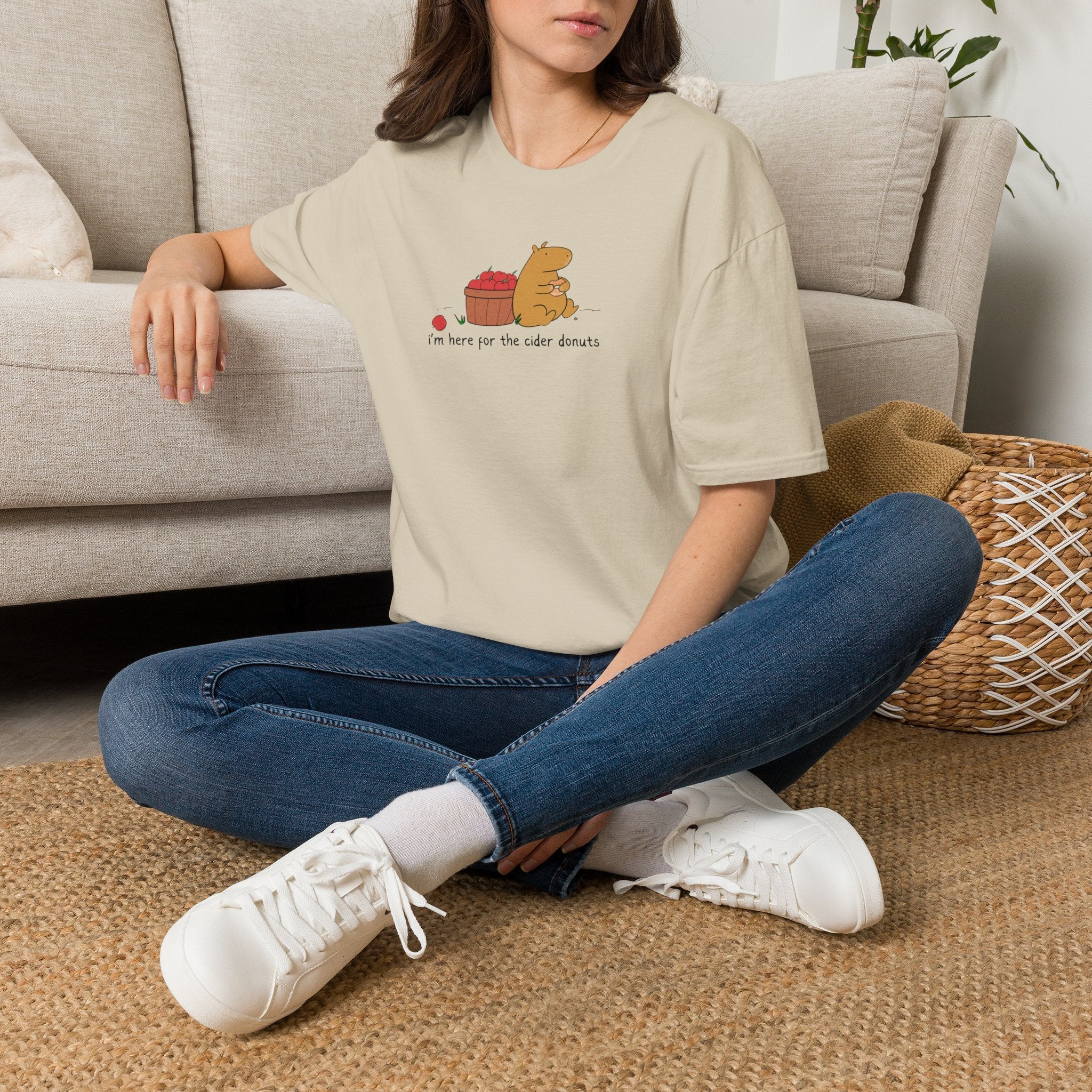 Capy Life softstyle t-shirt in beige featuring a hand-drawn capybara eating a cider donut next to a basket of apples.