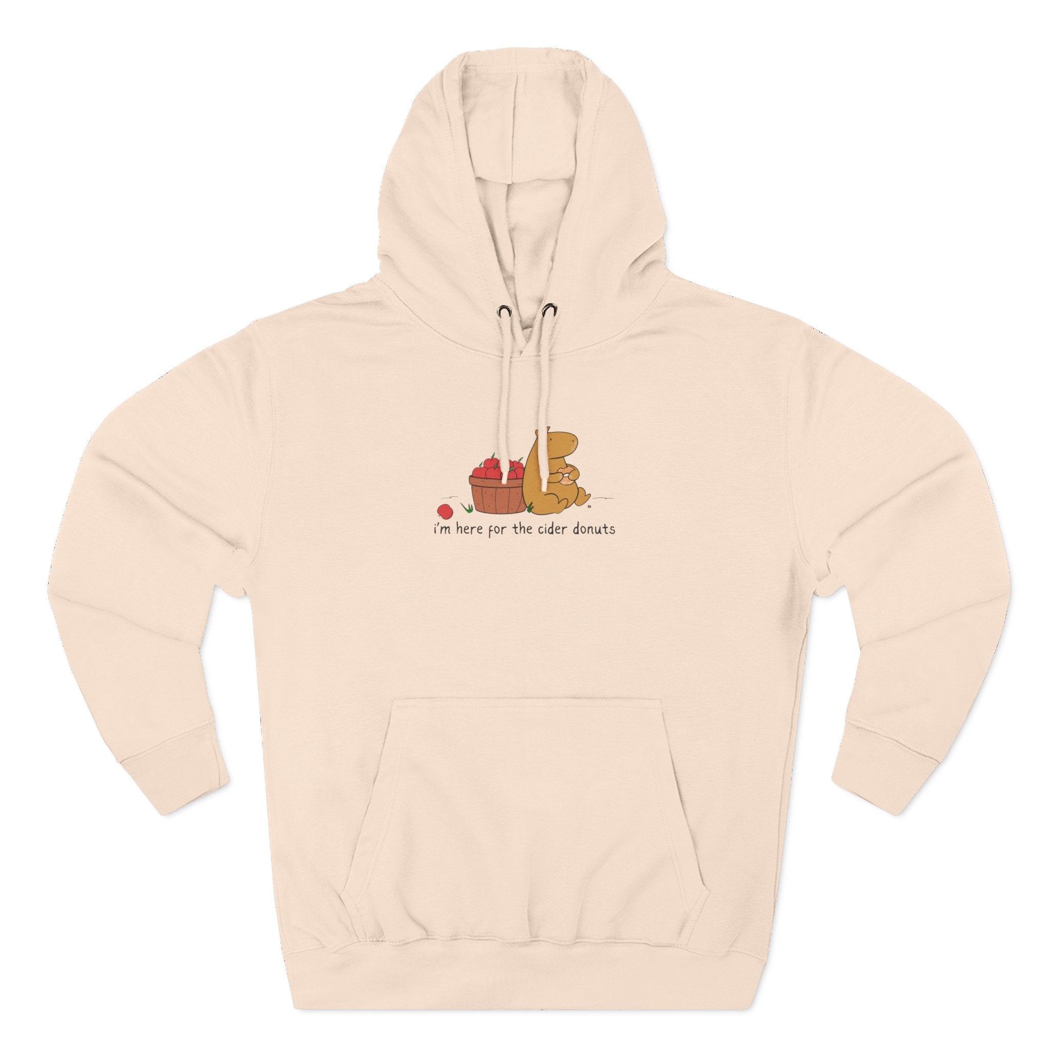 Capy Life beige fleece hoodie featuring a cute capybara eating a cider donut next to a basket of apples.