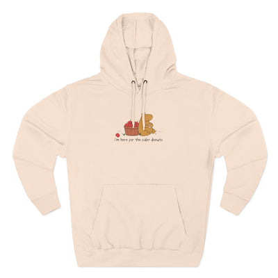 Capy Life beige fleece hoodie featuring a cute capybara eating a cider donut next to a basket of apples.