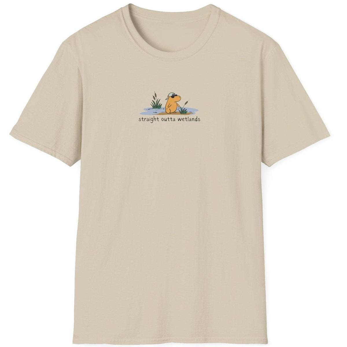 Capy Life beige softstyle t-shirt featuring a small hand-drawn capybara in a backwards hat with wetland cattails.