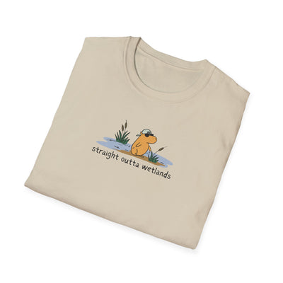 Capy Life beige softstyle t-shirt featuring a hand-drawn capybara wearing a backwards hat in a wetland scene.