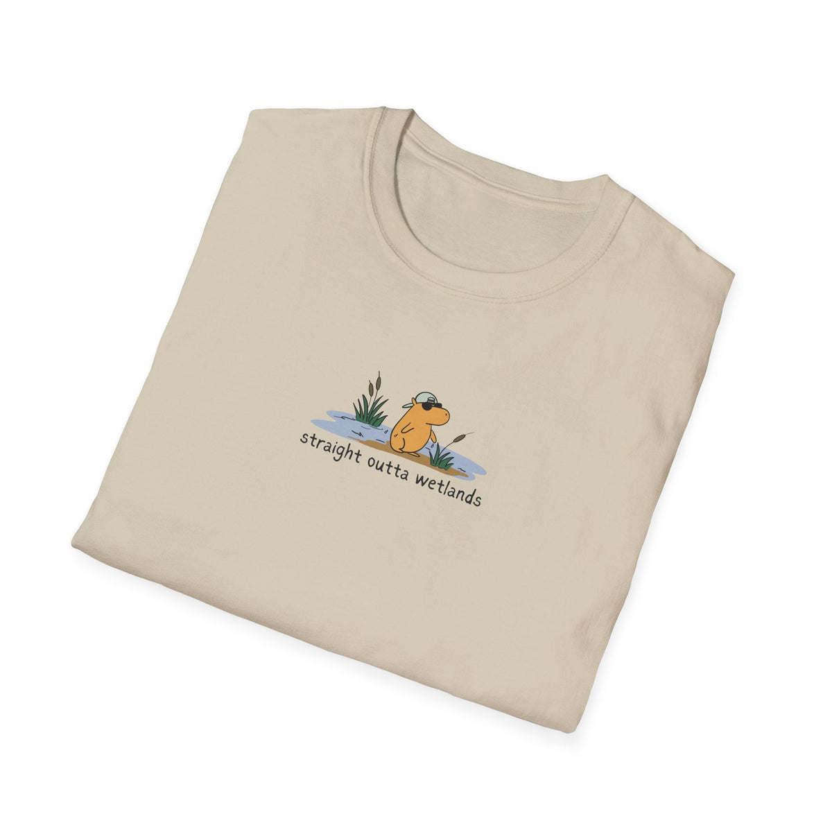 Capy Life beige softstyle t-shirt featuring a small, hand-drawn capybara in a backwards hat with wetland graphics.