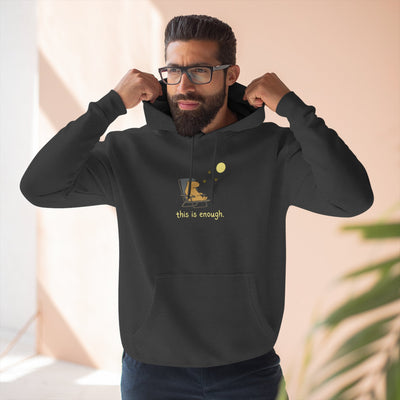 A man wearing a black Capy Life fleece hoodie with a minimalist capybara moonlit graphic and this is enough text.