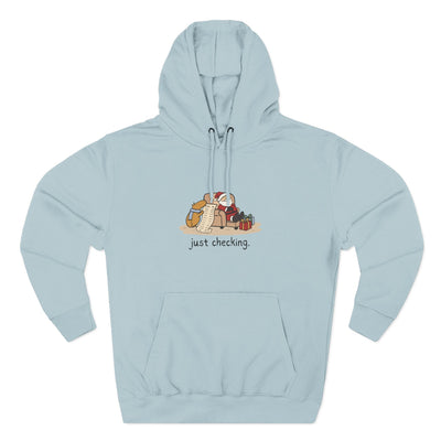Capy Life light blue pullover hoodie featuring a graphic of a capybara checking Santa's naughty or nice list.