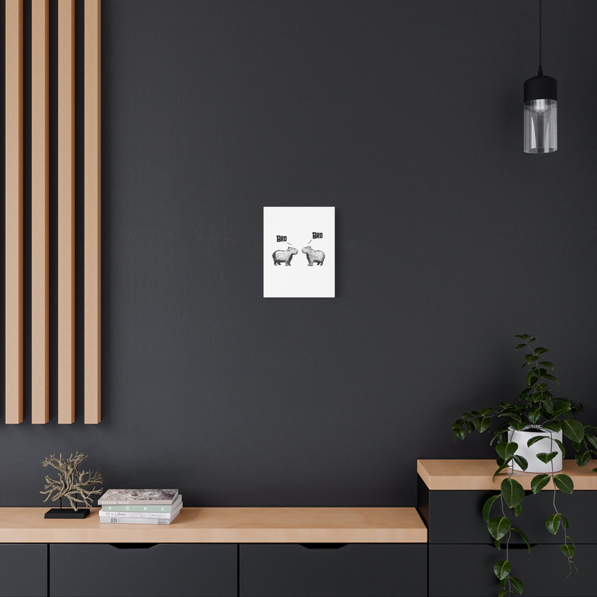 Capy Life Bro Bro capybara canvas wall art hanging on a dark grey wall above a wooden console table with decor.