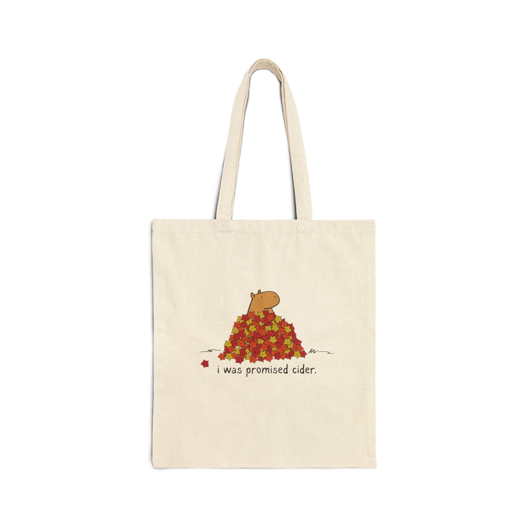 Capy Life natural canvas tote bag featuring a hand-drawn capybara in autumn leaves with the text I was promised cider