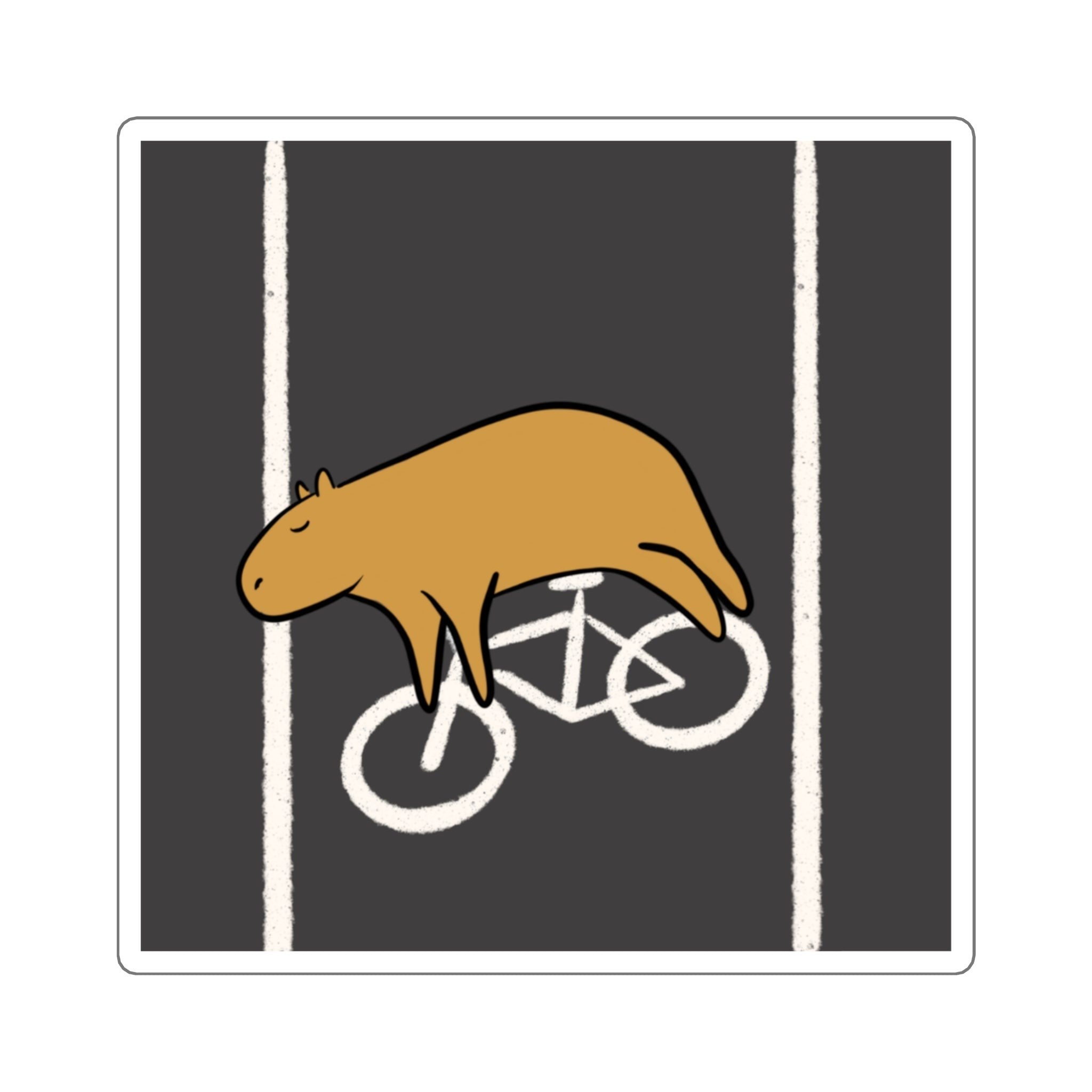 Capy Life vinyl sticker featuring a relaxed brown capybara lying across a white bike lane symbol on a charcoal background